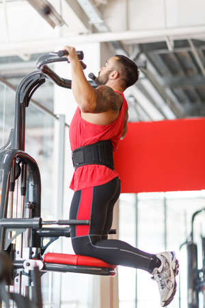 Rear view of fitness model with masculine physique in silhouette.