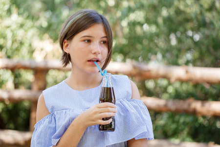 Pretty girl with fresh drink outdoors. Picnic on the nature.