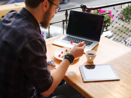 Happy young man working on tablet while sitting outdoors . Business concept.の写真素材