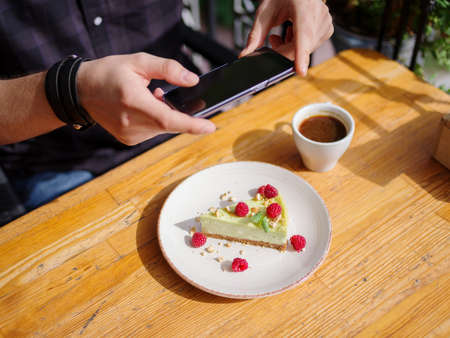 Happy young man working taking photo while sitting outdoors . Business concept.の写真素材