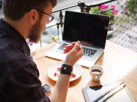 Happy young man working on tablet while sitting outdoors . Business concept.の写真素材