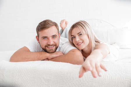 Sensual young couple together in bed. Happy couple in bedroom isolated on a white background.の写真素材