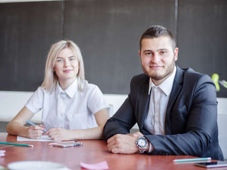 Wonderful colleagues sitting and talking about work. Pose on the camera for a working project.の写真素材