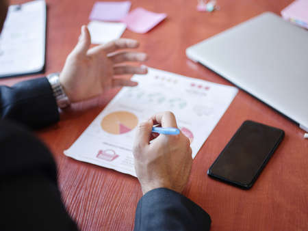 Mens hands work with documents on the wooden table. Business concept.