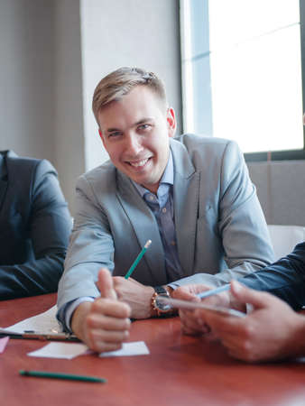 Young attractive business man talking to colleague in the office. Business concept.