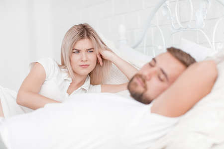 Sensual young couple together in bed. Happy couple in bedroom isolated on a white background.の写真素材