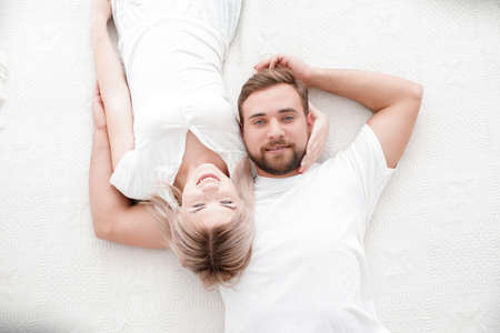 Sensual young couple together in bed. Happy couple in bedroom isolated on a white background.の写真素材