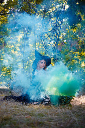 The forest enigmatic witch in the green wood outdoors.