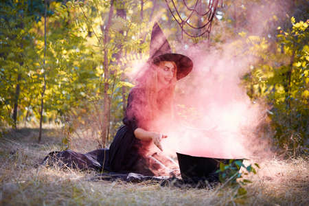 The forest enigmatic witch in the green wood outdoors.の写真素材