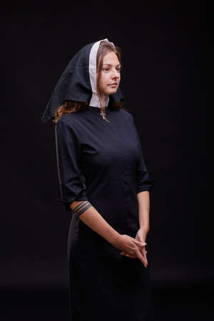 Pretty religious nun in religion concept against dark background.の写真素材