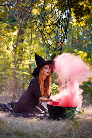 The forest enigmatic witch in the green wood outdoors.の写真素材