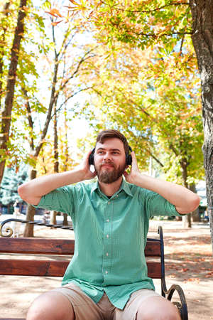 Young boy with black earphone on nature background.