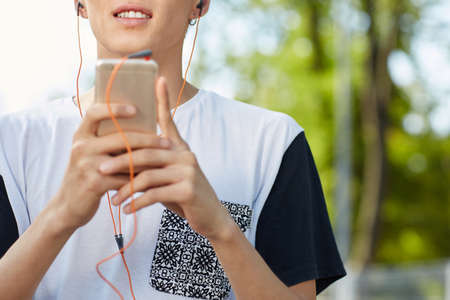 Close-up smiling man holding a phone on a blurred background. Progress and technology concept.の写真素材