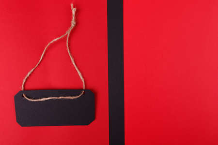 Close-up of two black and red backgrounds, on a bright red background arranged black tags.の写真素材