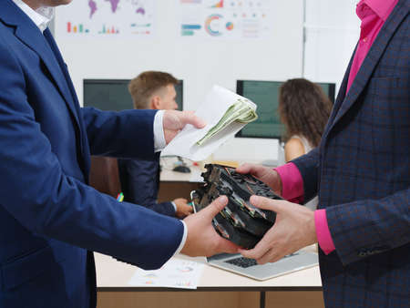 Close-up of a businessman giving money in an envelope for a video card. Cryptocurrency.の写真素材