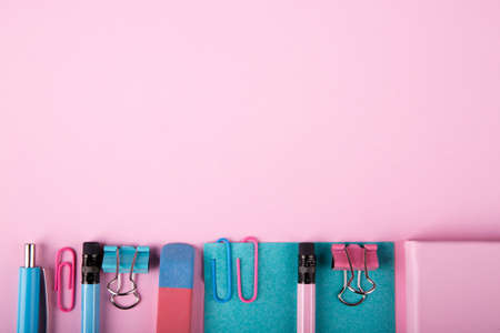 A close-up of a blue and pink office on a bright pink background. View from above. Blue and pink...