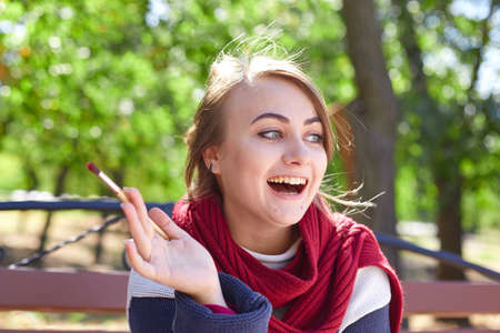 Beautiful artist draws a picture in a good mood outdoors.の写真素材