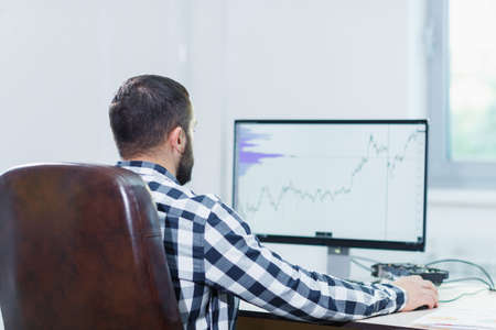 A man using software to manage projects on a laptop computerの写真素材