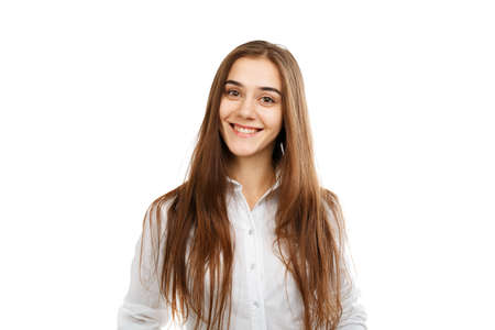 Portrait of a young beautiful girl on a white background, in a white blouse.の写真素材