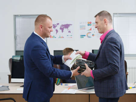 A person in the office gives money in an envelope for a video card. Cryptocurrency.の写真素材