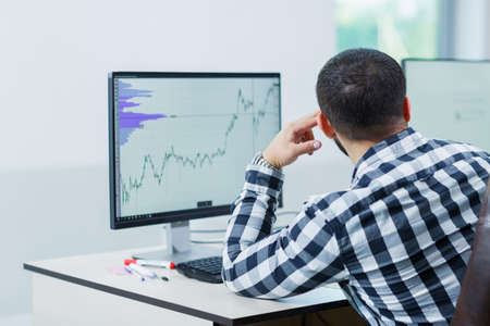 A man using software to manage projects on a laptop computerの写真素材