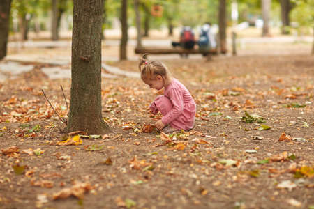 Beautiful little girl in a pink dress playing in the open airの写真素材