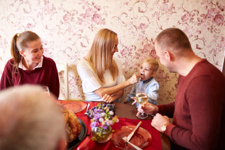 Happy mom and son at the Christmas or Thanksgiving dinner on a festive background. Family bonding concept.の写真素材