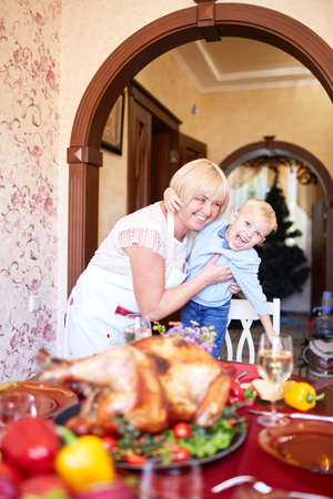 Grandmother and little boy having fun on Thanksgiving on a blurred background. Family holidays concept.の写真素材