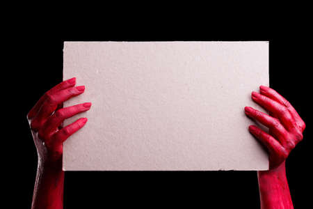 Human hands painted in red are posing on a black background. Halloween concept.の写真素材