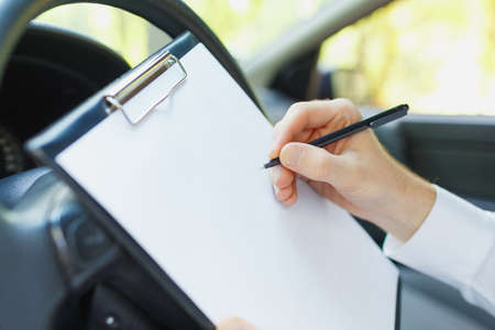 Attractive handsome elegant man in a business suit driving an expensive car.の写真素材