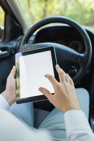 Attractive handsome elegant man in a business suit driving an expensive car.の写真素材