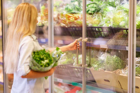 Pretty girl in fruit market with various colorful fresh fruits and vegetables. Food concept.の写真素材
