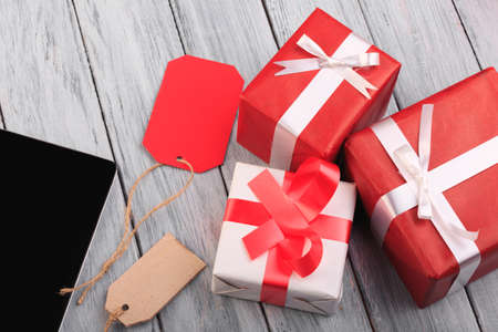 Beautiful gift boxes with a red and white bow on a wooden background.の写真素材