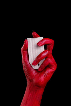 Human hands painted in red are posing on a black background.の写真素材