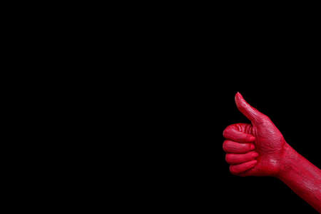 Human hands painted in red are posing on a black background.の写真素材