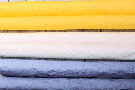 Top view of gift colored paper for packing gifts on a wooden surface.の写真素材