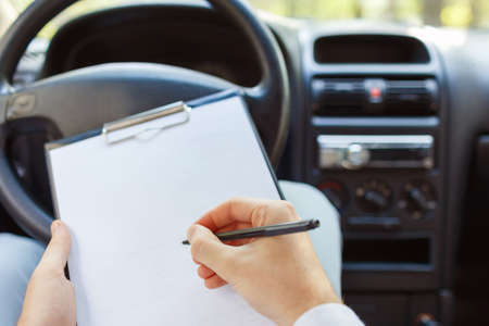 Attractive handsome elegant man in a business suit driving an expensive car.の写真素材