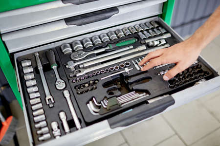 Hand on the background of a box with toolsの写真素材