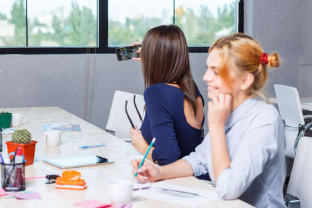 The girl makes selfie together with her colleagueの写真素材