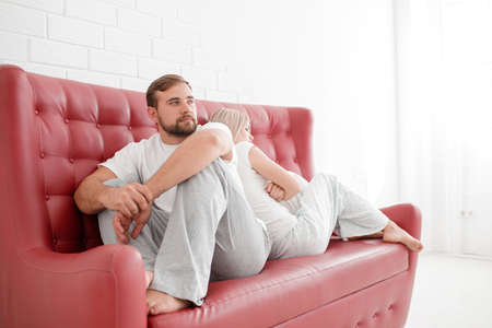 A man and a girl are sitting on a sofa on a white backgroundの写真素材