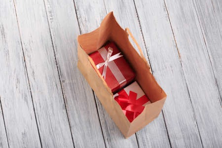 Christmas gifts wrapped in red wrapping paper in a shopping bag.の写真素材