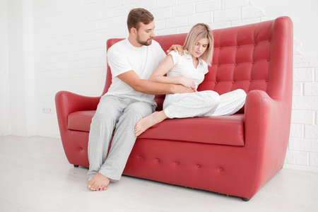 Man and supports the girl when her pain on a white backgroundの写真素材