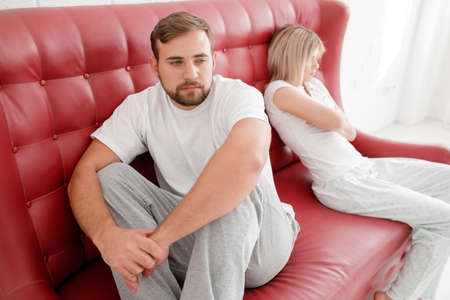 A man and a girl are sitting on a sofa on a white backgroundの写真素材
