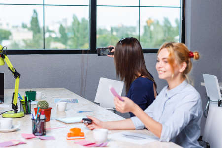 The girl makes selfie together with her colleagueの写真素材