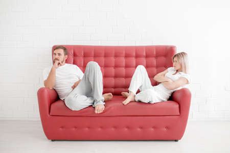 A man and a girl are sitting on a sofa on a white backgroundの写真素材