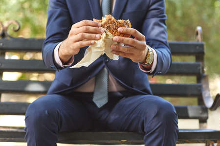 Lunch businessman who has a good, expensive watch in the park close upの写真素材