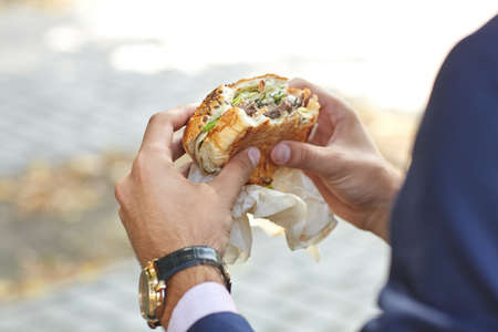 Lunch businessman who has a good, expensive watch in the park close upの写真素材