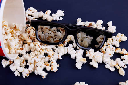 Spilled popcorn and 3d glasses on a blue background. Close-up. View from above.の写真素材