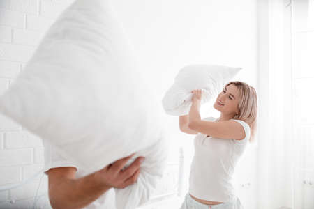 Beautiful young couple together in bed. Happy couple in bedroom on a white background.の写真素材