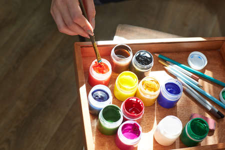 Bright colors of oil paints for drawing in a special wooden box. Different colors are red, yellow,...